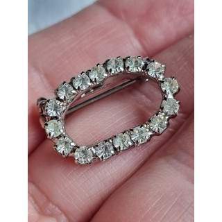 Liten oval nål med strass steiner rundt hele