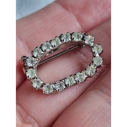 Liten oval nål med strass steiner rundt hele