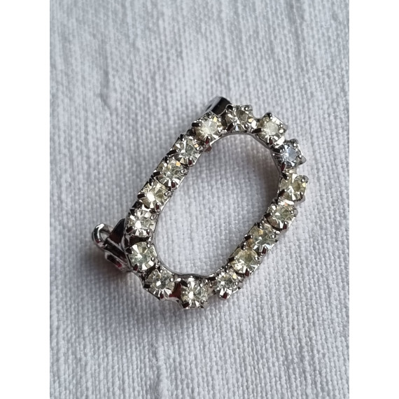 Liten oval nål med strass steiner rundt hele