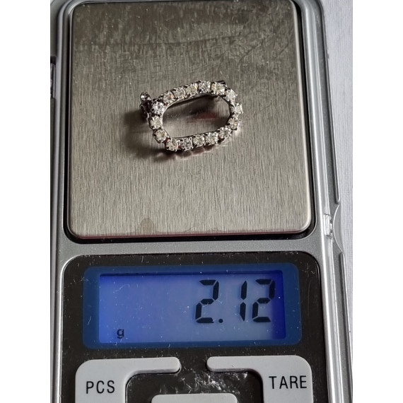 Liten oval nål med strass steiner rundt hele