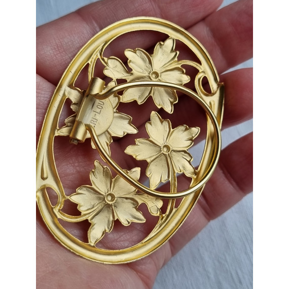 Nydelig forgylt skjerfklemme med oval ramme og blomster design