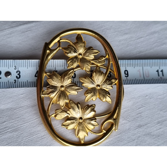 Nydelig forgylt skjerfklemme med oval ramme og blomster design