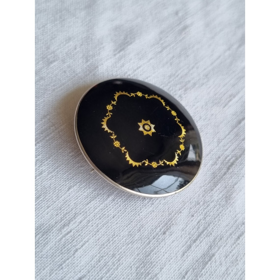 Sølv emalje nål, rund i sort blank emalje og gull dekor i en ring rundt en stjerne