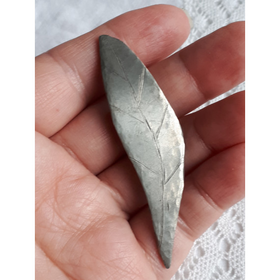 Et hjemmelaget blad nål i metall, med en nål på baksiden