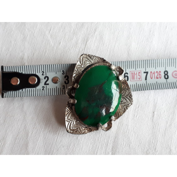 Flott sølvfarget nål med grønn stein. Noe trekantet i formen